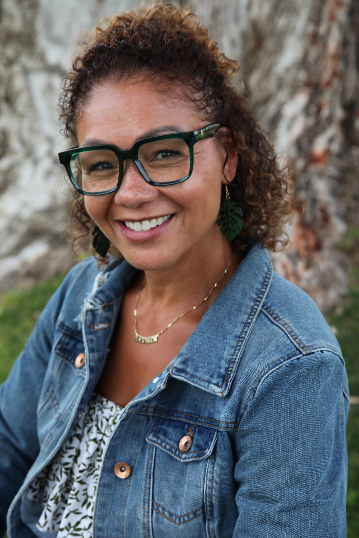 A woman wearing glasses and smiling for the camera.
