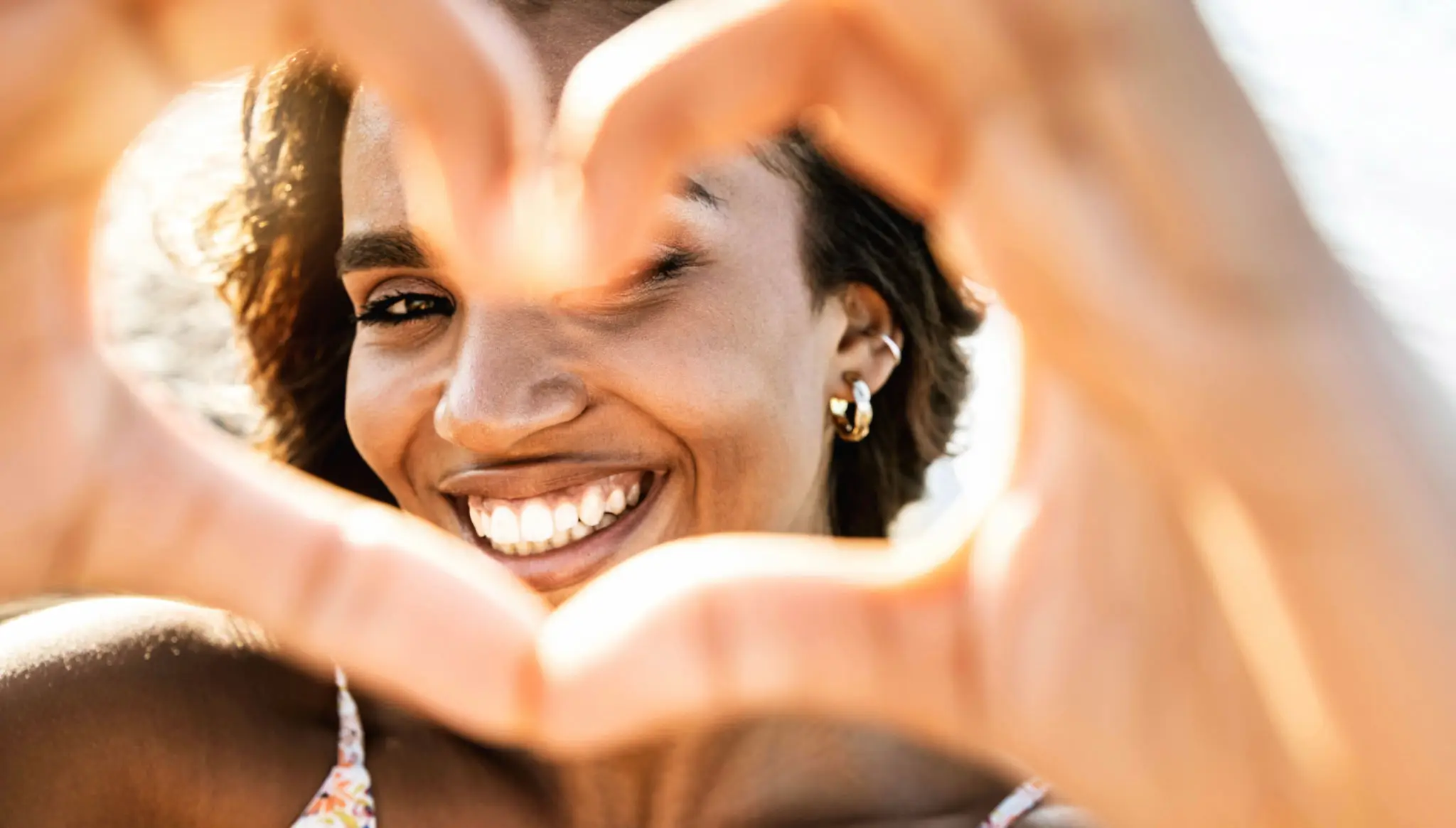 A woman making a heart sign with her hands.