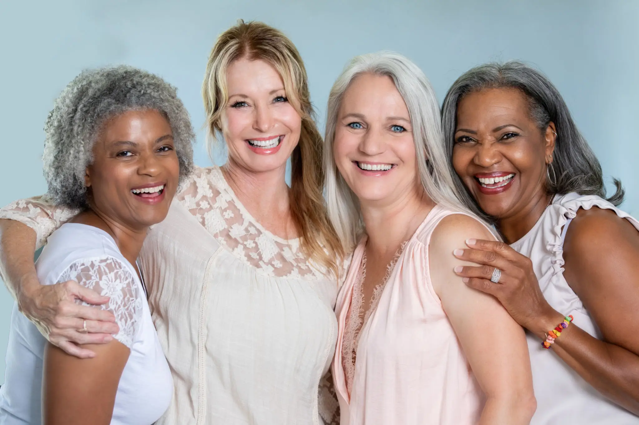 Four women smiling for a picture together.