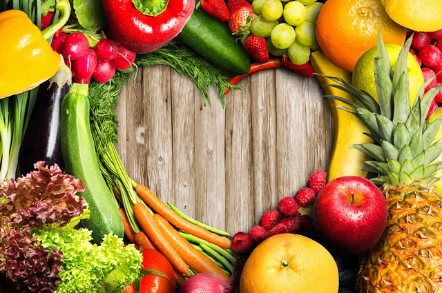 A heart shaped frame of fruits and vegetables.